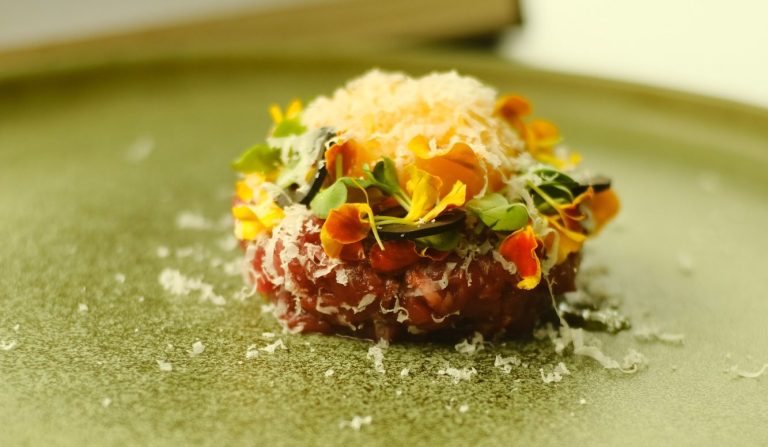 Teller mit elegant angerichteter Speise in einem gemütlichen Restaurantambiente.