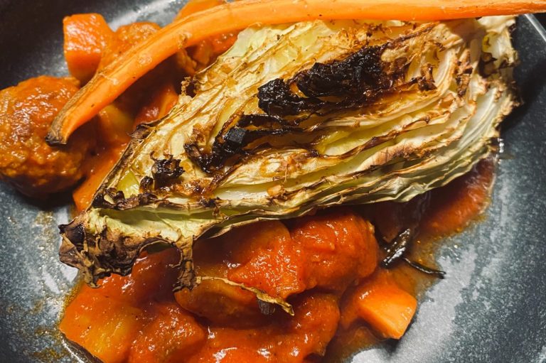 Gerösteter Kohl mit Karotten und Tomatensauce in einer Schüssel angerichtet.
